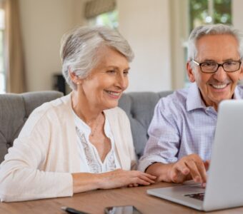 older couple looking at laptop while smiling