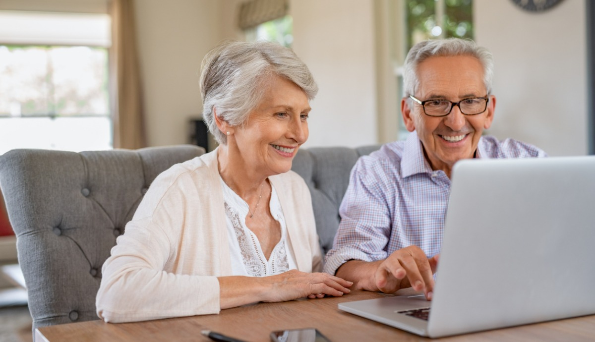 older couple looking at laptop while smiling