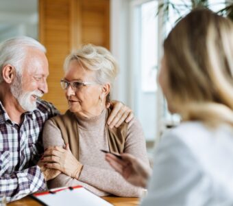 older couple looking at each other with woman in foreground holding clipboard