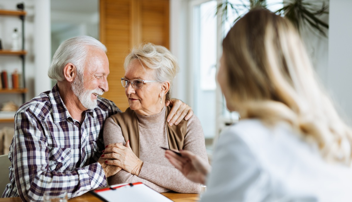 older couple looking at each other with woman in foreground holding clipboard