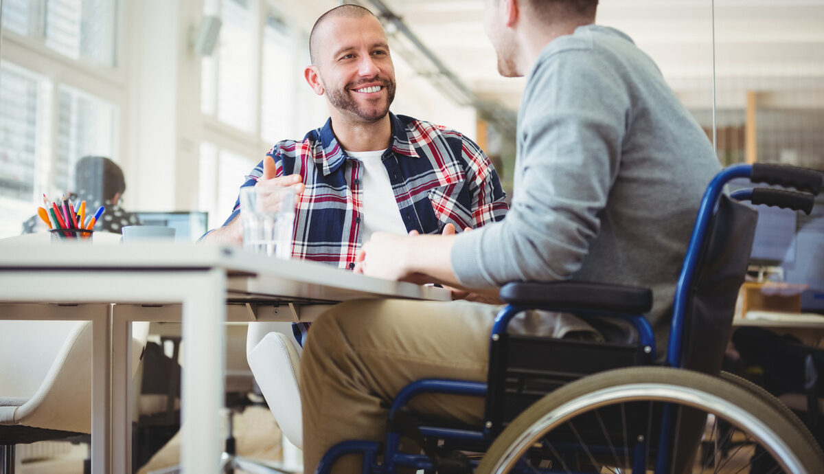 man talking to another man using a wheelchair