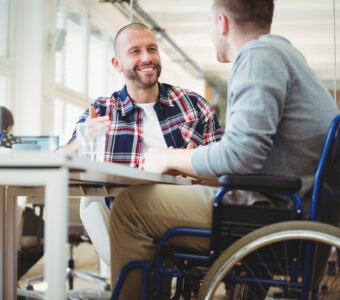 man talking to another man using a wheelchair
