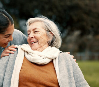 smiling aged care worker helping older adult