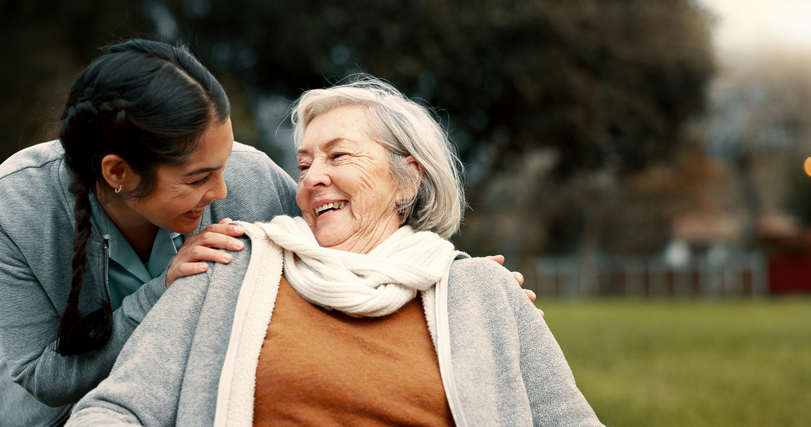 smiling aged care worker helping older adult