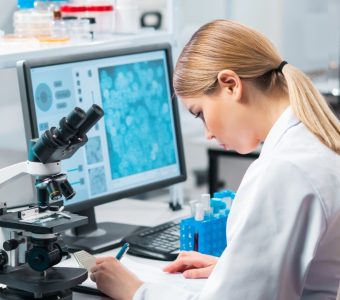 female scientist in lab writing notes