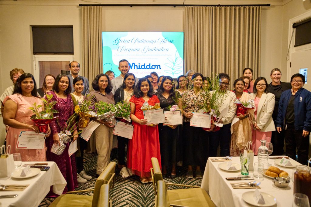 group of aged care nurse graduates standing with awards with Whiddon CEO Chris Mamarelis